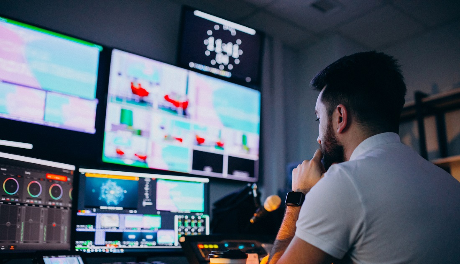 Ilustratīvs foto. Pārraides producents sēž pie ekrāna un pults.