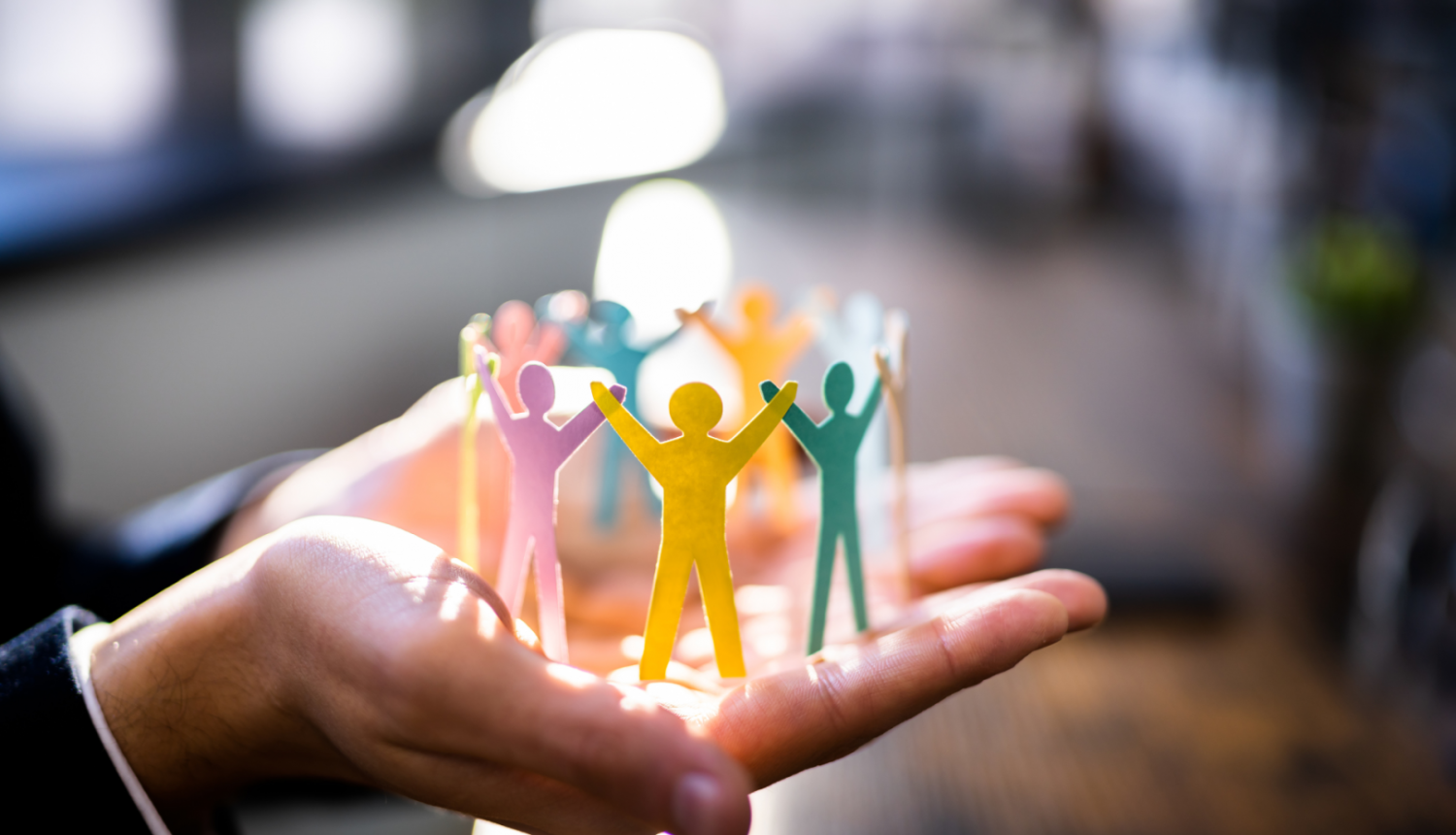 Cilvēka plaukstās papīra cilvēciņi 